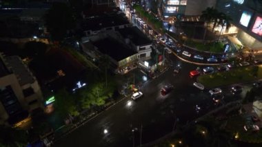 Gece aydınlatma jakarta şehri şehir merkezindeki trafik sokağı çatısı tepeden aşağı panorama 4k Endonezya