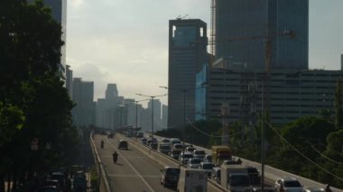 Güneşli bir akşam jakarta şehri inşaat trafiği sokak yaya köprüsü panorama 4k Endonezya