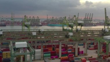 Günbatımı zamanı Singapur şehri dünyaca ünlü konteynır limanı, hava manzarası 4k