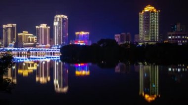 Sanya şehir gece zaman ışıklı nehir Körfezi Panoraması 4 k timelapse hainan Adası Çin yansıyan