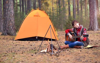 Genç kız ormandaki gitar çalmak