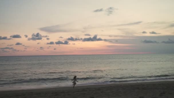 Mädchen läuft am Strand entlang und genießt den Sonnenuntergang — Stockvideo