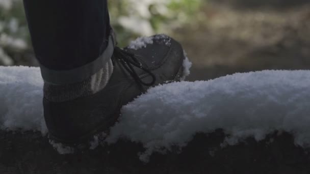 Homem de botas andando na estrada nevada — Vídeo de Stock