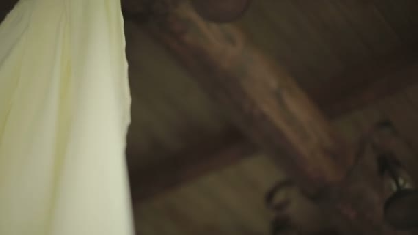 robe de mariée blanche accrochée à une maison en bois 