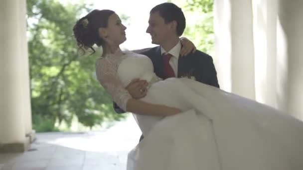 El novio levanta a la novia en sus brazos — Vídeo de stock