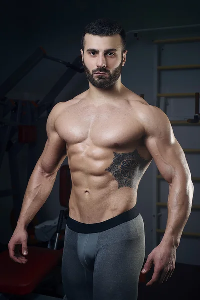 Muskulöser Mann oben ohne posiert in der Turnhalle — Stockfoto