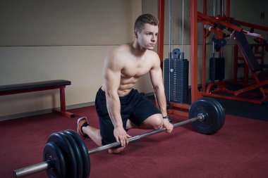 Barbell ile oturan kas üstsüz adam