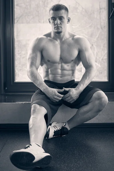 체육관에 창턱에 앉아 근육 남자 — 스톡 사진