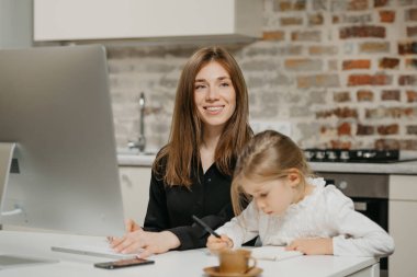 Gülümseyen bir anne, kızı evdeki deftere resim çizerken gözlerini kaçırıyor. Güzel bir anne, sarışın çocuğunun yanındaki bilgisayarda çalışıyor ve özenle mektuplar yazıyor..