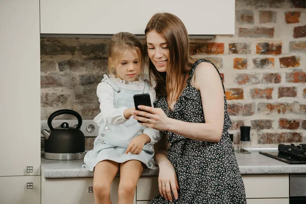 Bělošská Matka Bledou Pletí Čte Zprávy Telefonu Dcerou Kuchyni Matka — Stock fotografie