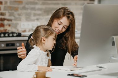 Genç, gülümseyen bir anne evdeki ücra iş yerinde kızına ders veriyor. Güzel bir anne, sarışın çocuğuna bazı şeyler anlatıyor..
