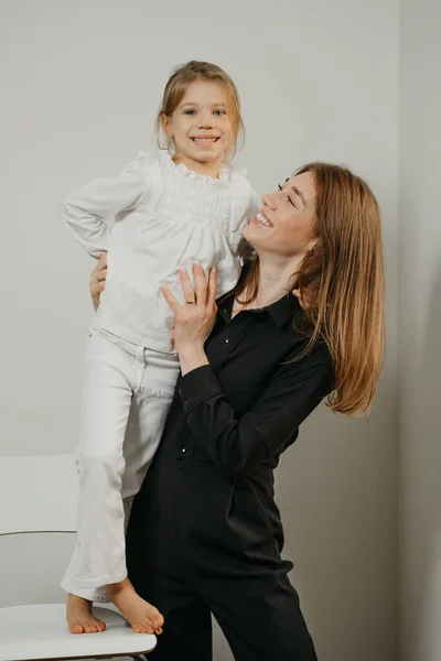 Uma Jovem Mãe Linda Está Abraçando Sua Filha Que Está — Fotografia de Stock