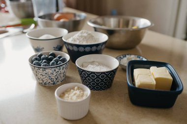 Buğday unu, badem unu, şeker, pudra şekeri, yabanmersini, iki parça tereyağı, nişasta, yumurta, limon mutfakta limonlu turta için hazırlanıyor..