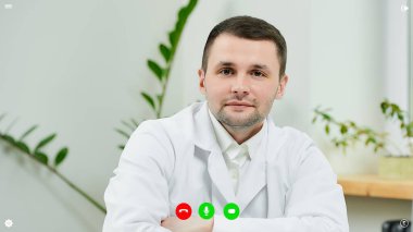 İnternetteki doktor randevusu sırasında doktorun hastayı dinlediği görüntülü konuşma sırasında telekomünikasyon uygulamasının masaüstü ekran görüntüsü.