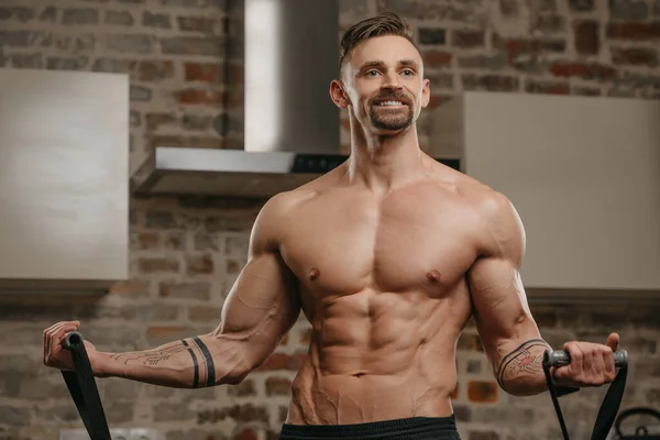 Muscular Man Working Out Elastic Pull Rope His Apartment Athletic — Stock Photo, Image