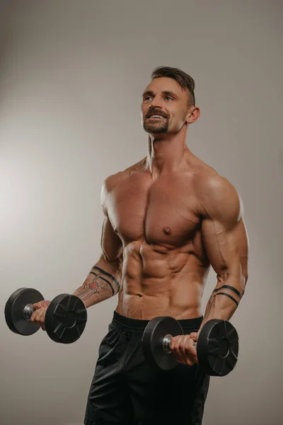 Muskularny Facet Brodą Robi Loki Bicepsów Hantlami Sportowiec Demonstruje Swój — Zdjęcie stockowe