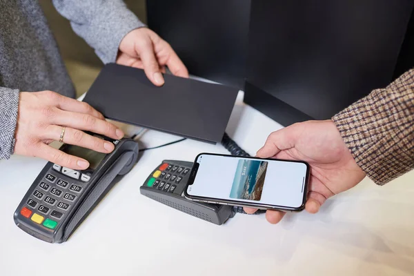 Nfc 디지털 지갑을 지불하면서 스마트폰을 고객의 손이다 계원은 무능력 터미널에서 — 스톡 사진