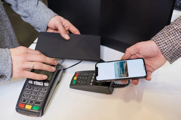 Nfc 현금을 출납원에게 지불하는 휴대폰을 고객의 가까운 손이다 무능력 종착지에서의 — 스톡 사진