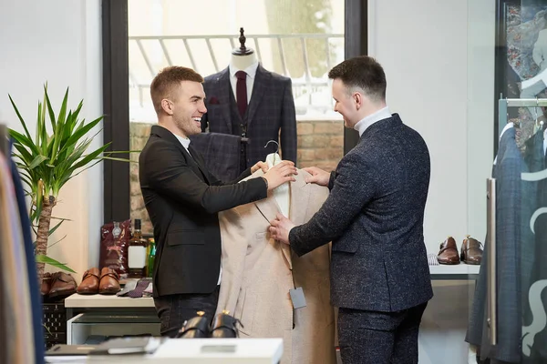 Assistente Loja Sorrindo Está Demonstrando Casaco Para Homem Com Uma — Fotografia de Stock