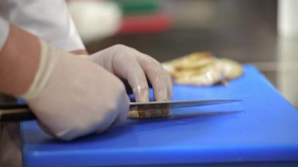一部特写影片 内容是一位戴一次性手套的男性厨师在厨房切虾子时的双手 — 图库视频影像