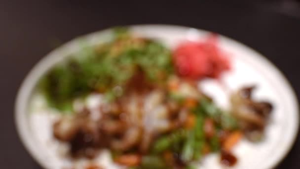 用生姜 烤蔬菜和八爪鱼倒入酱油和芝麻制成的白色陶瓷盘的动人视频 — 图库视频影像