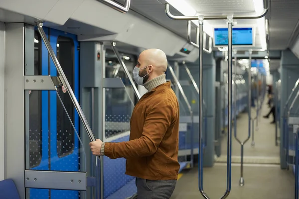 코로나 바이러스가 퍼지는 수염을 기르고 남자가 난간을 지하철을 준비를 마스크쓴 — 스톡 사진
