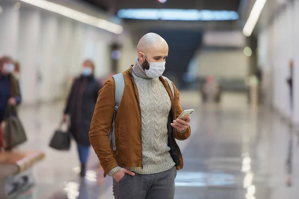 Hombre Con Una Máscara Facial Médica Está Usando Teléfono Inteligente —  Fotos de Stock