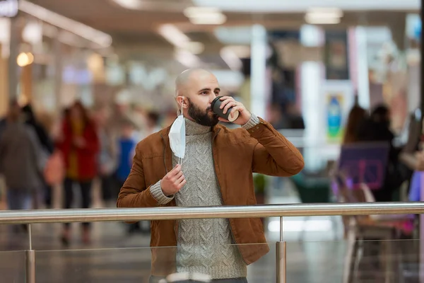 Ένας Άντρας Πίνει Καφέ Ενώ Βγάζει Μια Μάσκα Προσώπου Στο — Φωτογραφία Αρχείου