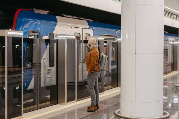 코로나 바이러스가 퍼지지 않도록 의료용 마스크를 남자가 지하철에서 현대적 열차를 — 스톡 사진