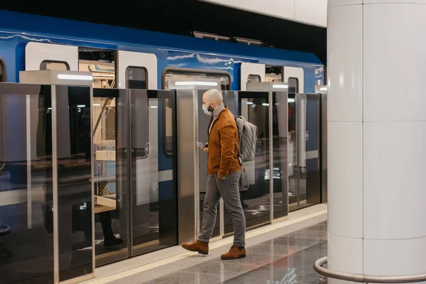 코로나 바이러스의 확산을 피하기 의료용 마스크를 지하철에 들어가는 휴대폰을 외과용 — 스톡 사진