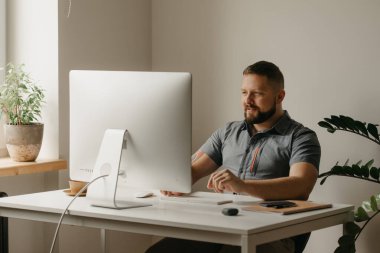 Gülümseyen bir adam uzaktan kumanda bilgisayarında çalışır. Sakallı bir adam, evdeki bir video konferansında iş arkadaşının raporu sırasında daktilo yazıyor. Bir öğretmen çevrimiçi ders veriyor..