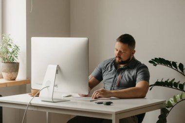 Bir adam uzaktan kumandalı bir bilgisayarla çalışıyor. Sakallı bir adam evdeki bir video konferansı sırasında okutman konuşmasını not alıyor. Bir öğretmen online bir derse hazırlanıyor..