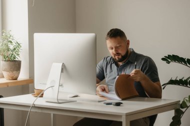 Bir adam uzaktan kumandalı bir bilgisayarla çalışıyor. Sakallı bir adam evdeki bir video konferansı sırasında defterde bilgi arıyor. Bir öğretmen online bir derse hazırlanıyor..