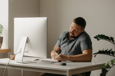 Bir adam uzaktan kumandalı bir bilgisayarla çalışıyor. Sakallı bir adam evdeki bir telefon görüşmesi sırasında not alıyor. Bir öğretmen online bir derse hazırlanıyor..