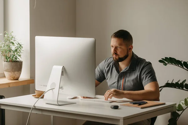 Hombre Trabaja Remotamente Una Computadora Escritorio Tipo Con Barba Está — Foto de Stock
