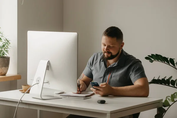 Hombre Sonriente Trabaja Remotamente Una Computadora Escritorio Tipo Con Barba — Foto de Stock