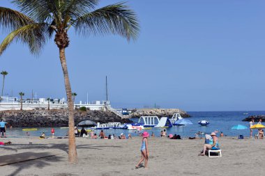 Costa Adeje, Tenerife, Kanarya Adaları, İspanya - 27 Temmuz 2025: İnsanlar sıcak bir yaz gününde La Pinta plajında güneşleniyor.