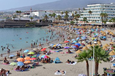 Costa Adeje, Tenerife, Kanarya Adaları, İspanya - 27 Temmuz 2025: İnsanlar La Pinta plajında güneşlenip yüzüyor.