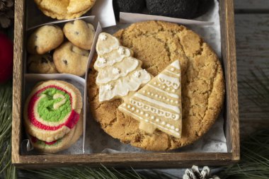 Noel hediyesi olarak süslenmiş ahşap bir kutuda çeşitli Noel kurabiyeleri Noel arifesi aşçılık gelenekleri