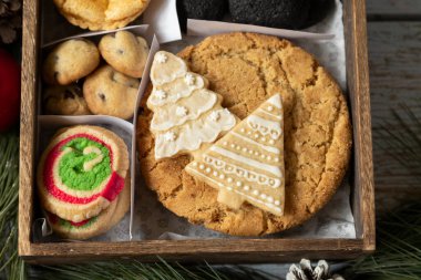 Noel hediyesi olarak süslenmiş ahşap bir kutuda çeşitli Noel kurabiyeleri Noel arifesi aşçılık gelenekleri
