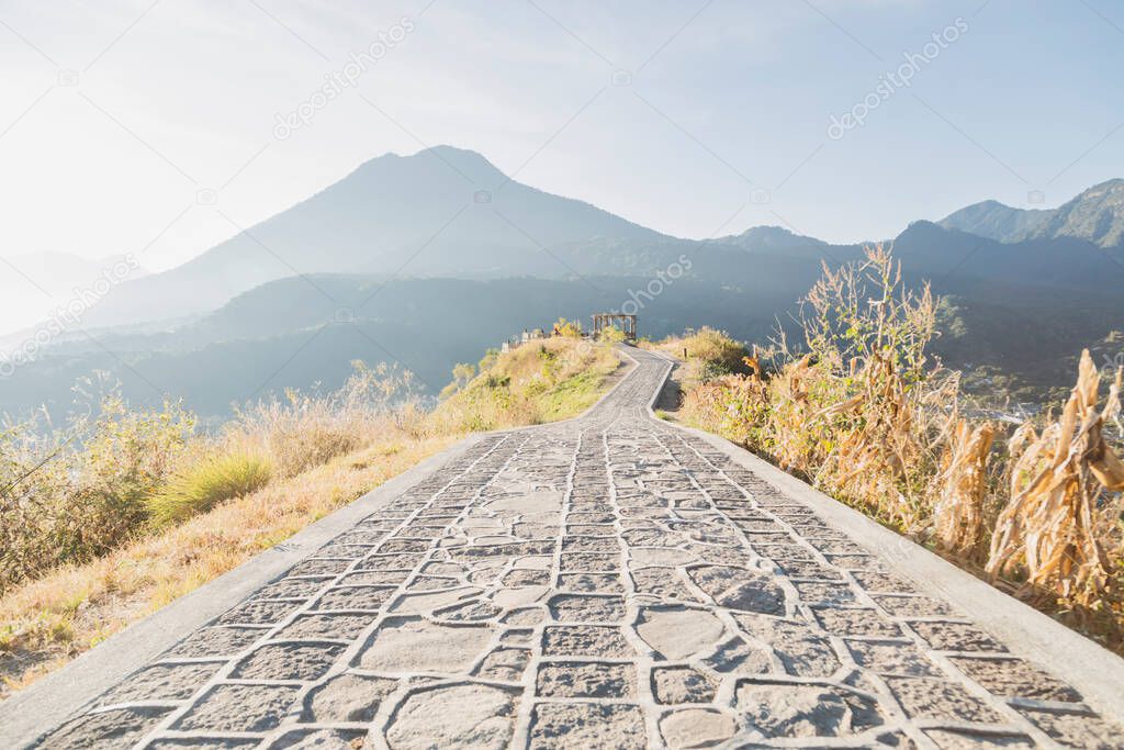 Road in the middle of the mountain top with view to the volcanoes and mountains in San Juan la Laguna in Guatemala at sunrise - landscape of volcanoes and mountains with the first rays of sun