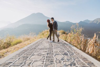 Gündoğumunda dağın tepesinde birbirine sarılan gezgin çift arkalarında volkanlara ve dağlara aşık İspanyol çift Guatemala 'da maceracı bir çift.