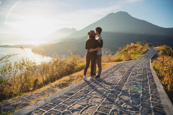 İspanyol çift Atitlan Gölü 'nde güneşin doğuşunu seyrediyor. San Juan la Laguna' da manzaranın tadını çıkaran gezgin çift.