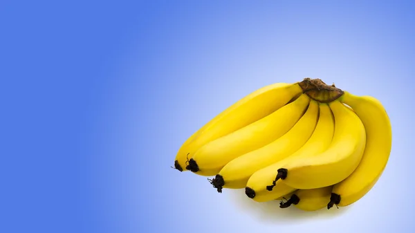 Kilka banany na białym tle na niebieskim tle — Zdjęcie stockowe