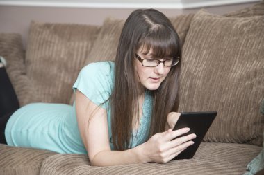 Bir dijital kitap ile kanepede rahatlatıcı