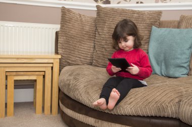 Kanepe izle çizgi film Tablet Pc kenarında oturan yürümeye başlayan çocuk