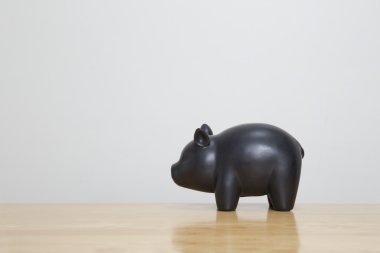 Ahşap masa üzerinde siyah kumbara