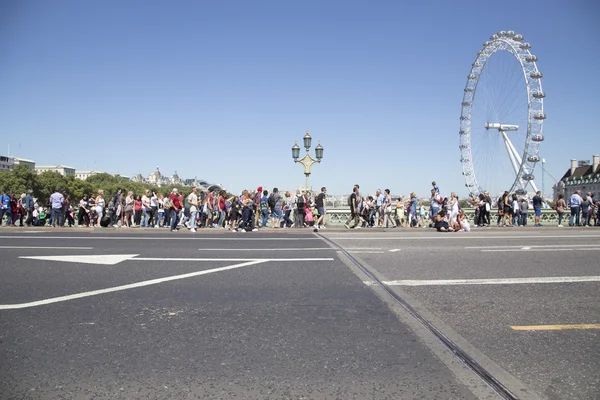 Turistas andando sobre ponte wesminster e olhando para Londres ey — Fotografia de Stock