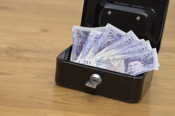 Dinero en caja de seguridad en tabel de madera — Foto de Stock