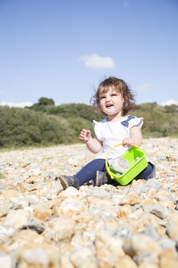 Bir çakıl plajı üzerinde oturan